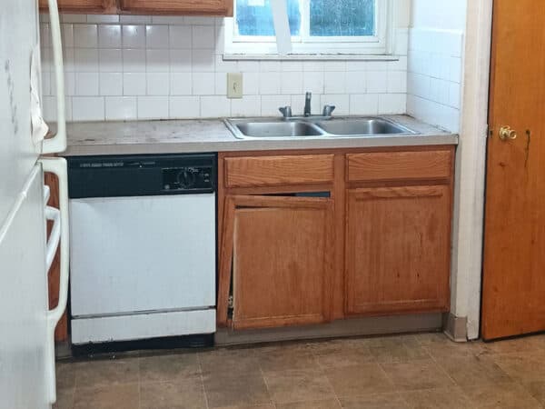 Kitchen with wooden cabinets, double sink, and dishwasher.