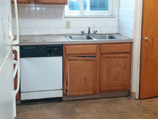 Kitchen with wooden cabinets, sink, and dishwasher in a residential home.