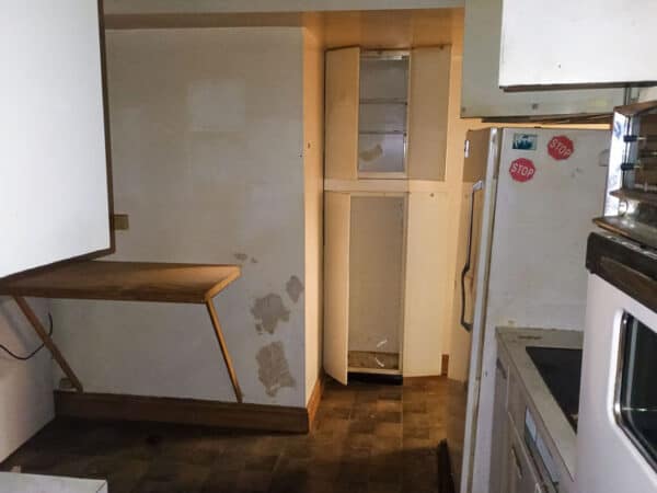 Interior view of a kitchen with a small wooden table and a refrigerator.