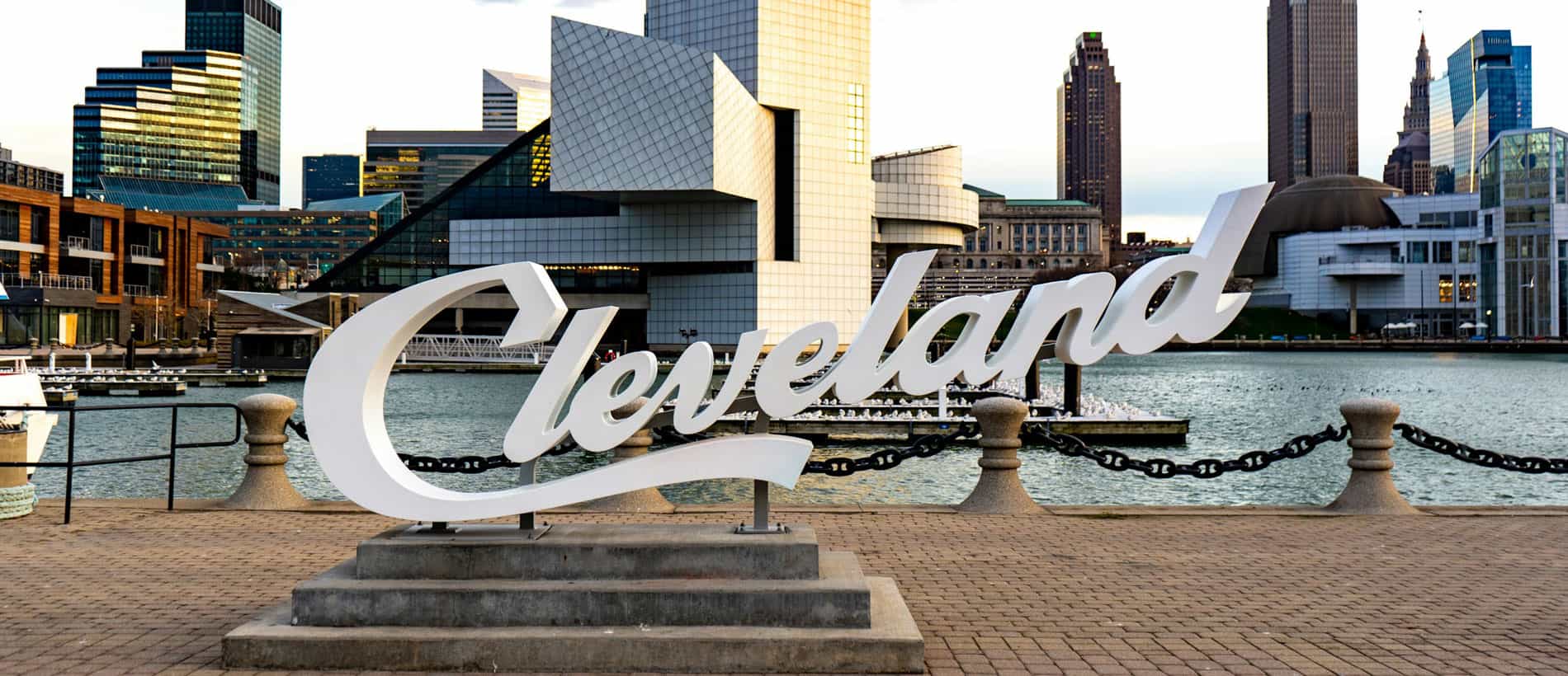 Cleveland skyline with waterfront and cityscape, featuring the Cleveland sign in foreground.