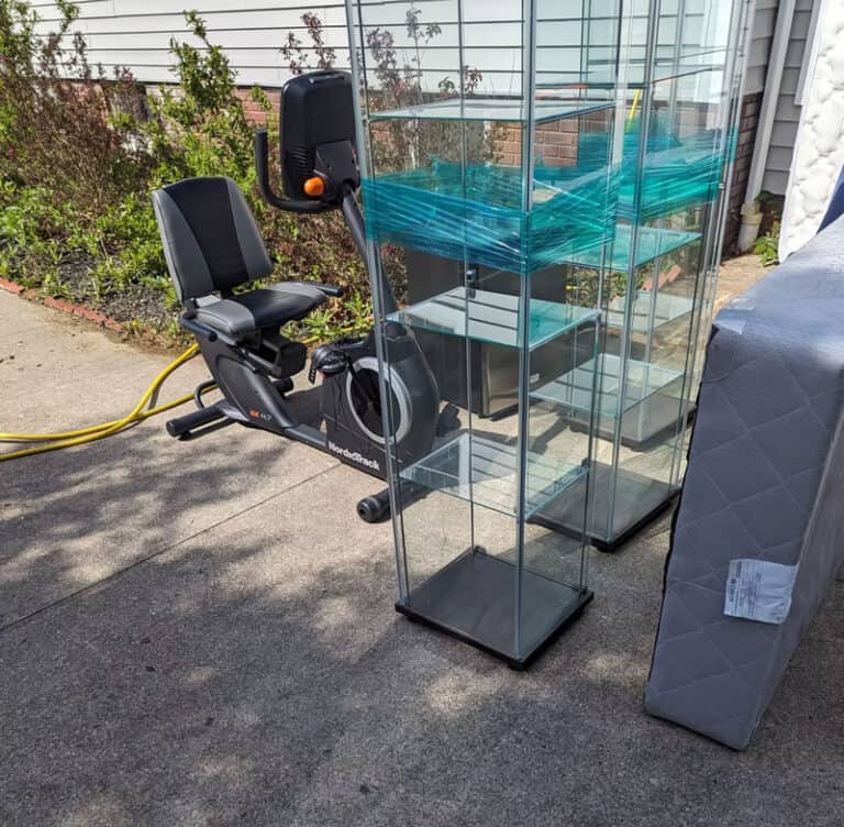 Exercise bike and glass display case outside property.