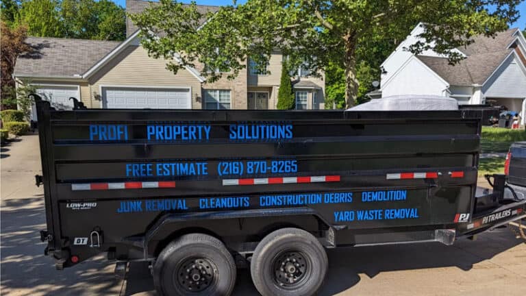 Dumpster truck with Profi Property Solutions LLC branding in a residential area.