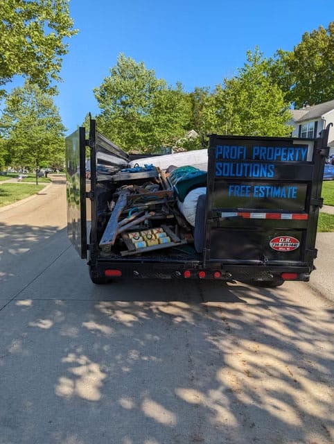 Moving truck with debris for Profi Property Solutions LLC in a residential area.